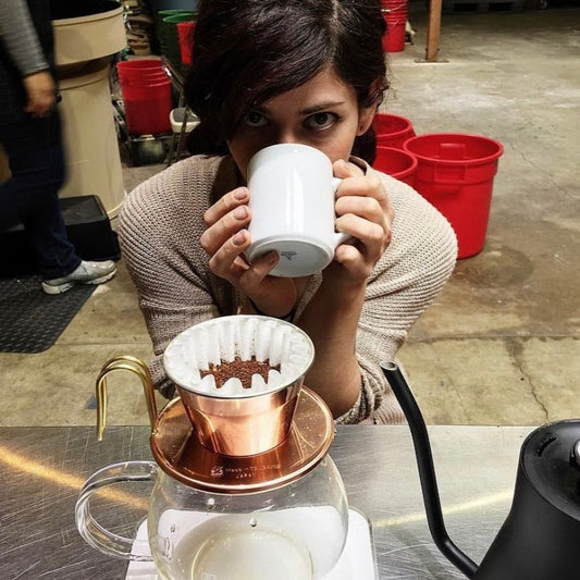 Roaster Mandy prepping and tasting pour over coffee.