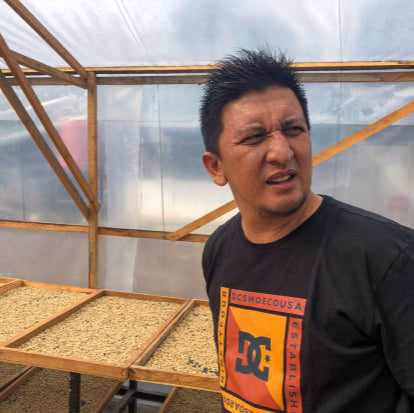 Iwannitosa Putra of Putra Mill in Aceh, Sumatra standing in a coffee drying tent.