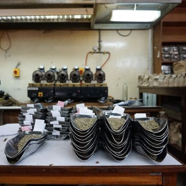 A coffee lab in Kenya showing shelves and tables containing scoops, bags. and sample roasters.